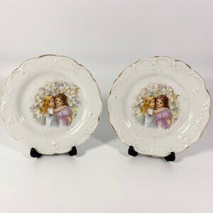 Set of 2 small plates girls hugging each other comes with stands.